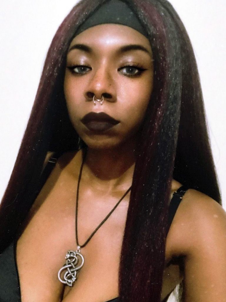 Black woman with long straight black hair with red front bangs