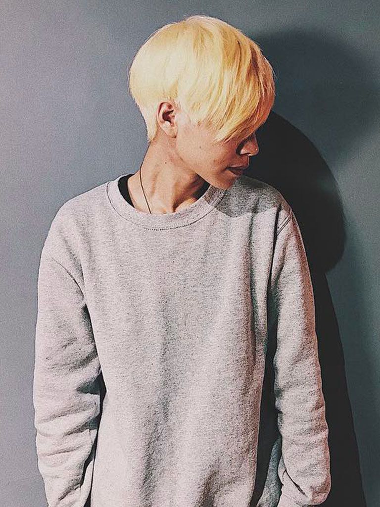 Woman in profile with blonde choppy mushroom cut with long fringe
