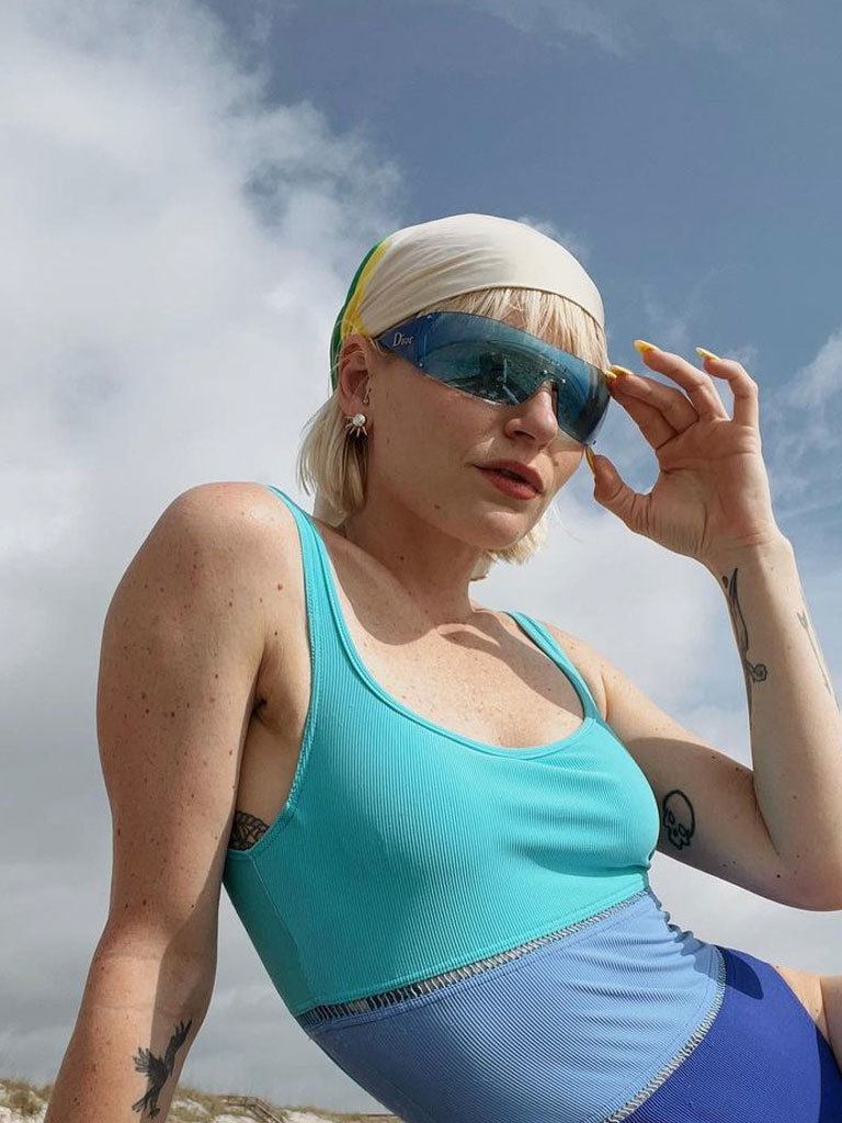woman with mushroom hair cut with a silk scarf as headscarf, at the beach