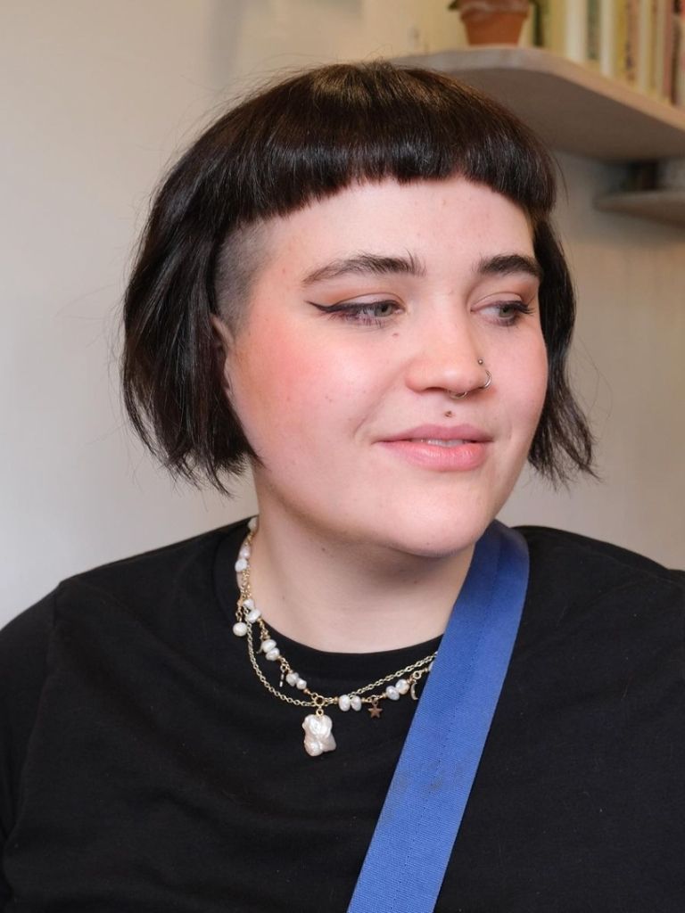 Woman with brown short rounded baby bangs