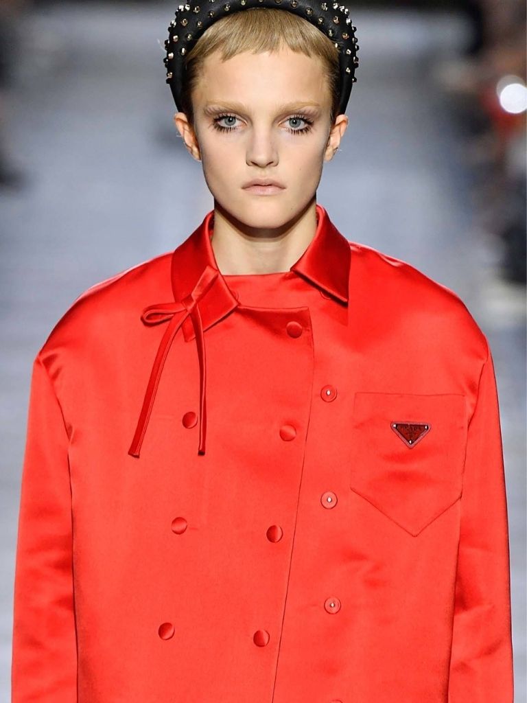Short bangs: Model with blonde hair wearing a large headband with micro bangs at Prada.