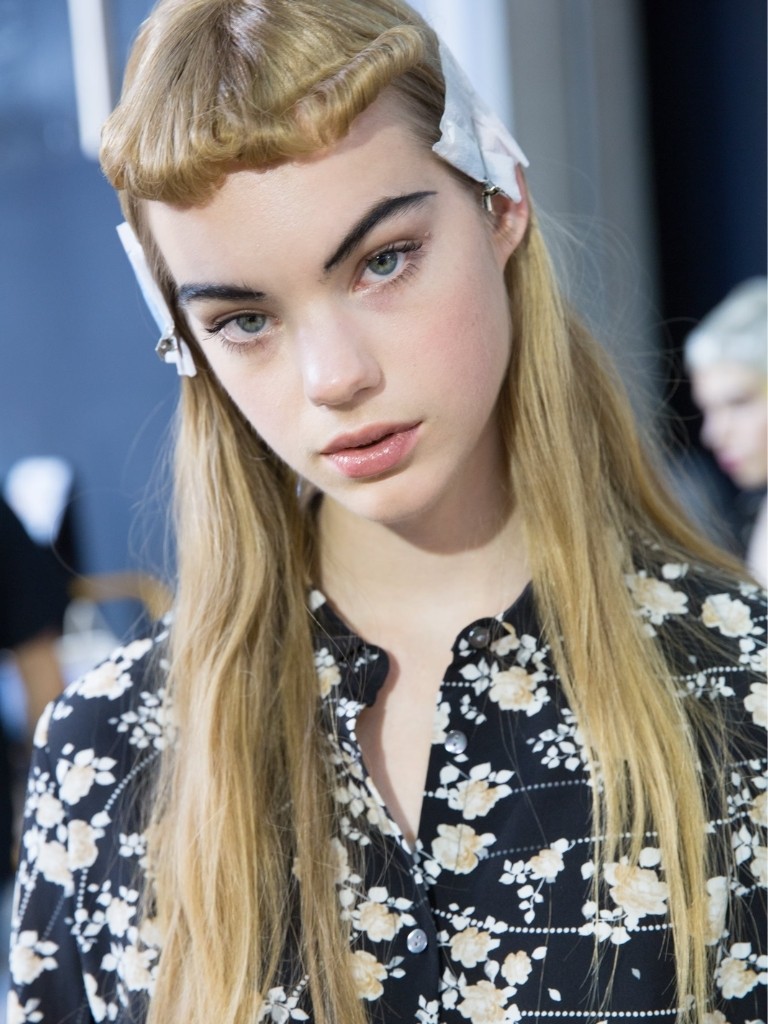 Short bangs: Blonde model with long hair and retro rolled micro short fringe backstage at fashion show.