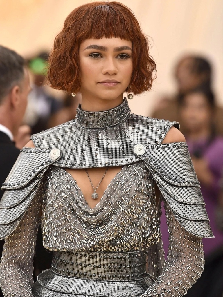 Short bangs: Zendaya witth deep red wavy bob and short bangs wearing silver outfit.