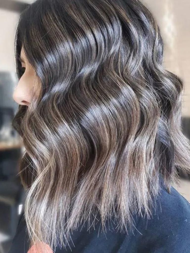 Woman with wavy tonal ash brown hair