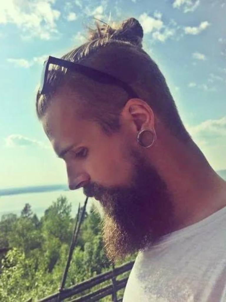 front view of a man with a beard and a man bun hairstyle undercut