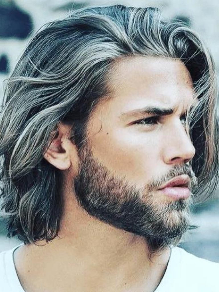 side view of a man with longer hair and a beard
