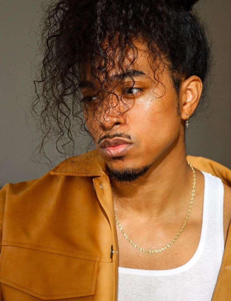 Man with curly hair and long bangs.