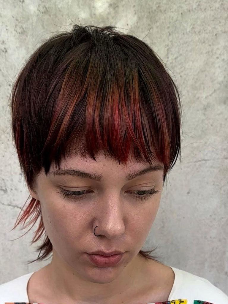 Woman with red balayage hair in a mushroom haircut with mullet back