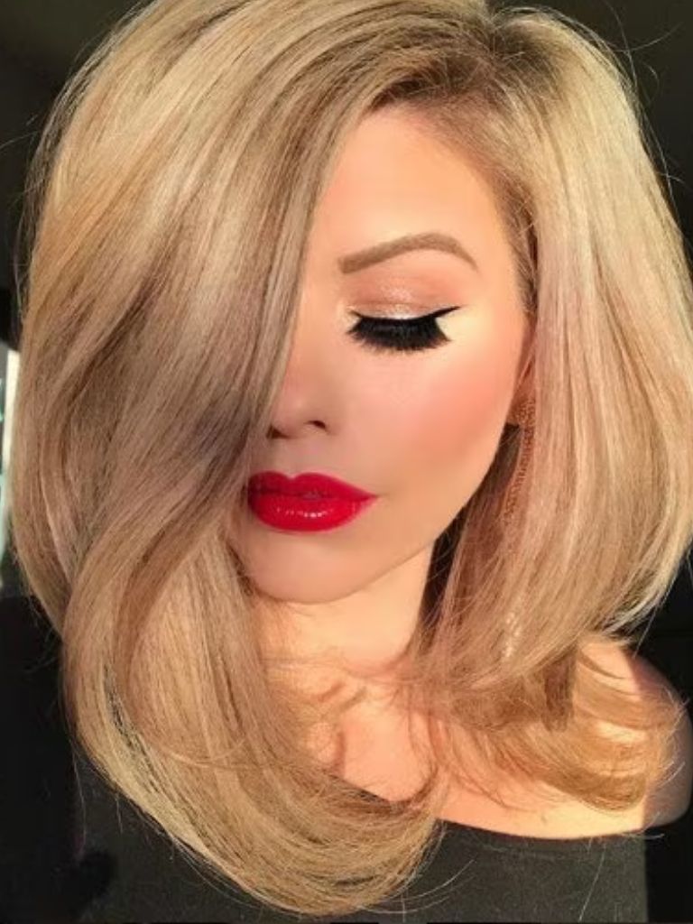 image of a woman front facing with blonde wavy hair in a bob and red lipstick