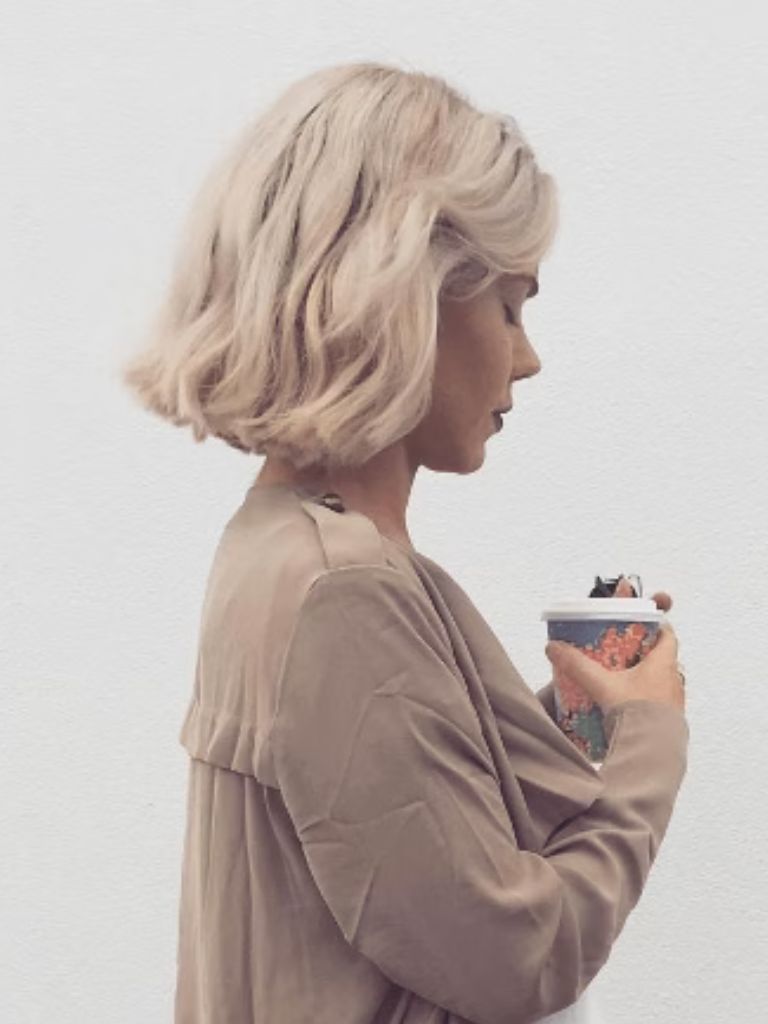 side view of a woman with wavy blonde bob