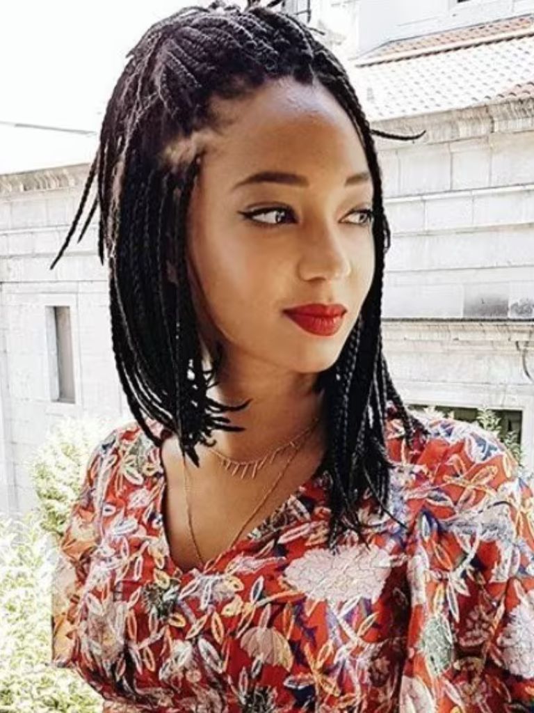 Box braids bob: Woman with dark brown box braids in a bob style smiling, wearing floral dress