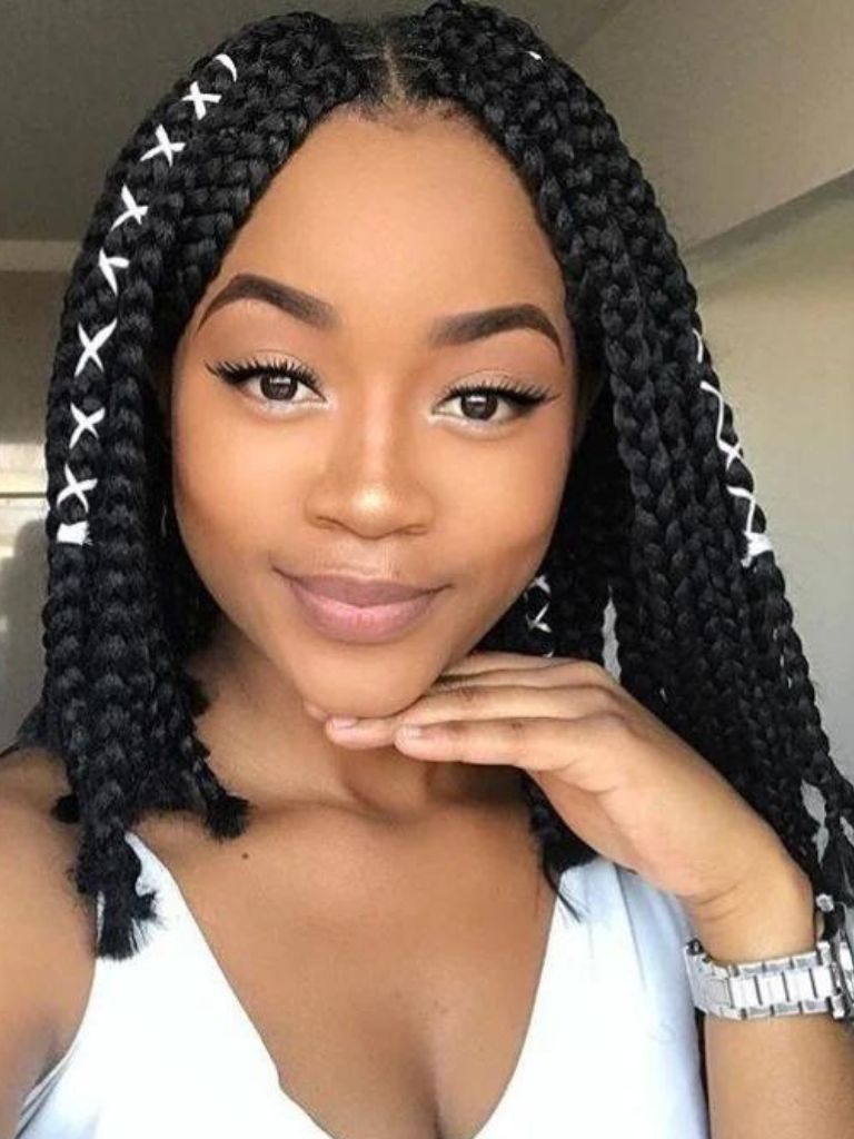 Box braids bob: Woman with dark brown box braids bob hairstyle, with accessories in it