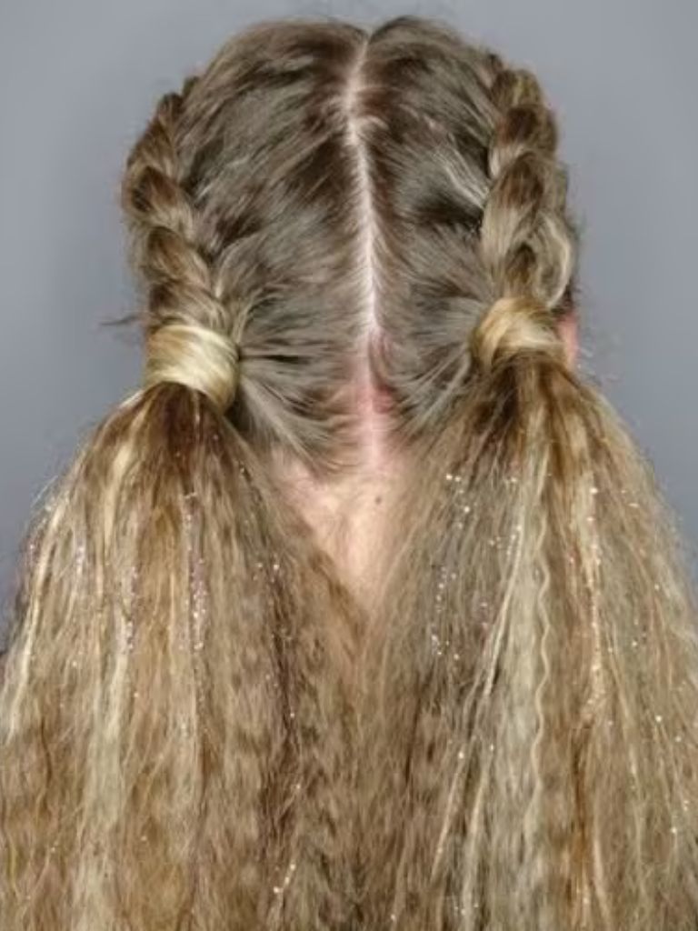 Crimped hair: Woman with long crimped blonde hair styled in two french braids.