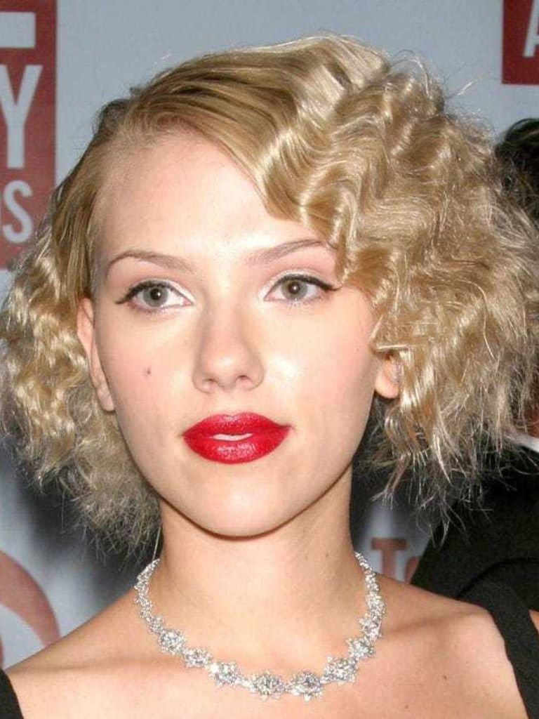 Crimped hair: Scarlett Johansson with short blonde wavy hair with bold red lips.