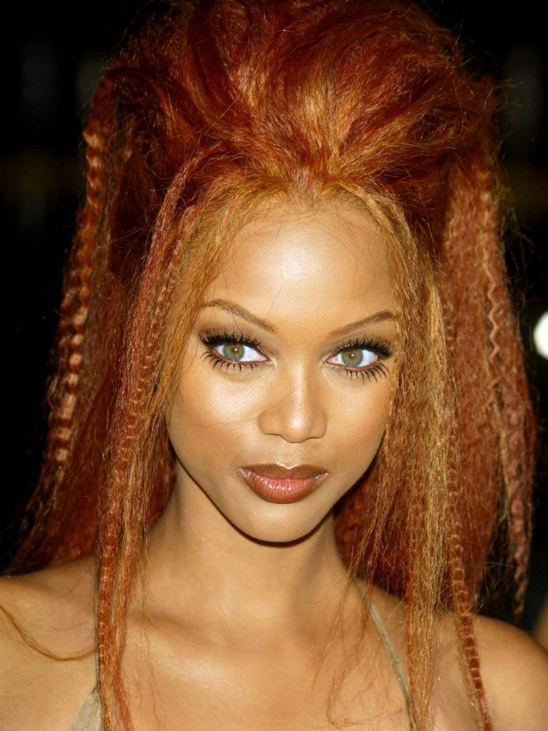 Crimped hair: Tyra Banks with copper red long crimped hair in updo ponytail.