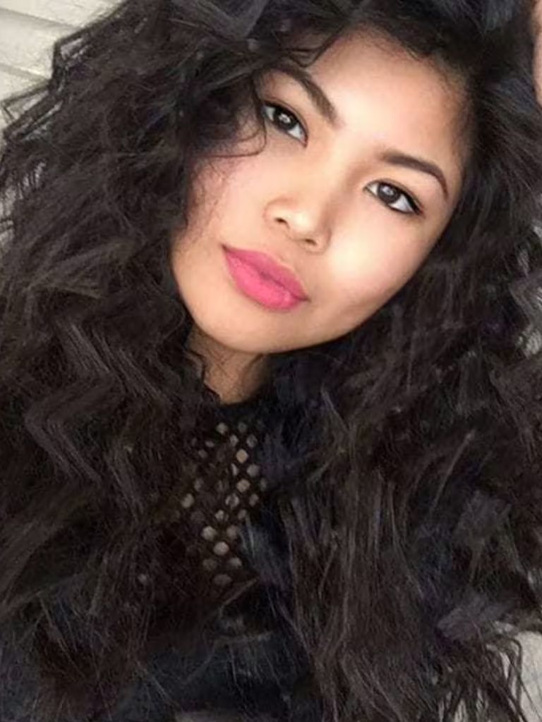 Crimped hair: Woman touching her long dark brown hair in crimped zig-zag pattern.