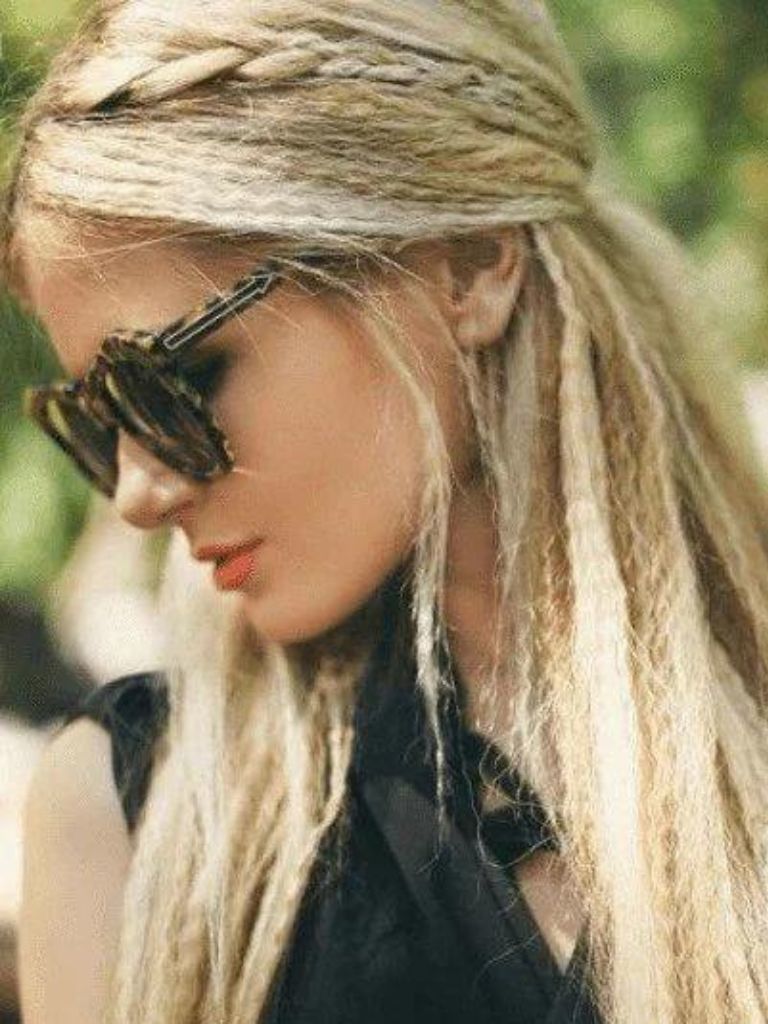 Crimped hair: Woman with long blonde crimped hair in half-up, half-down finish wearing dark sunglasses.