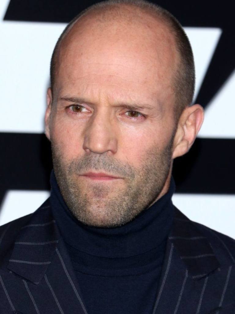 Hairstyles for receding hairline: Close-up headshot of Jason Statham with shaved head and stubble