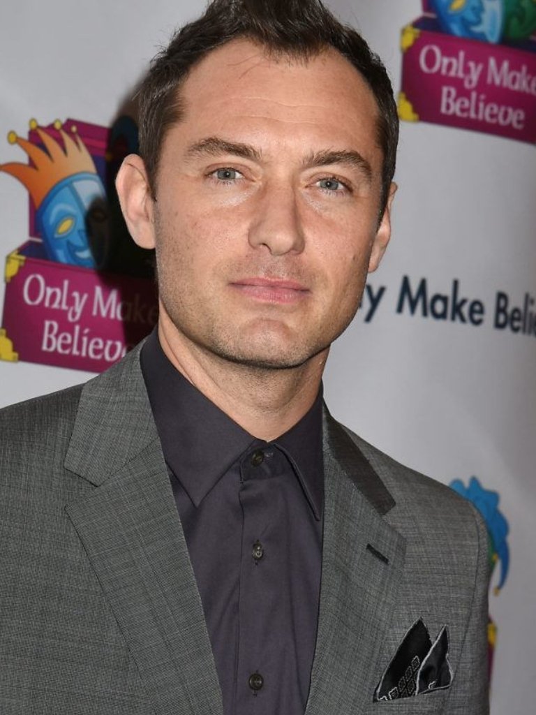 Hairstyles for receding hairline: Jude Law with brown hair in a mohawk style, wearing a grey suit