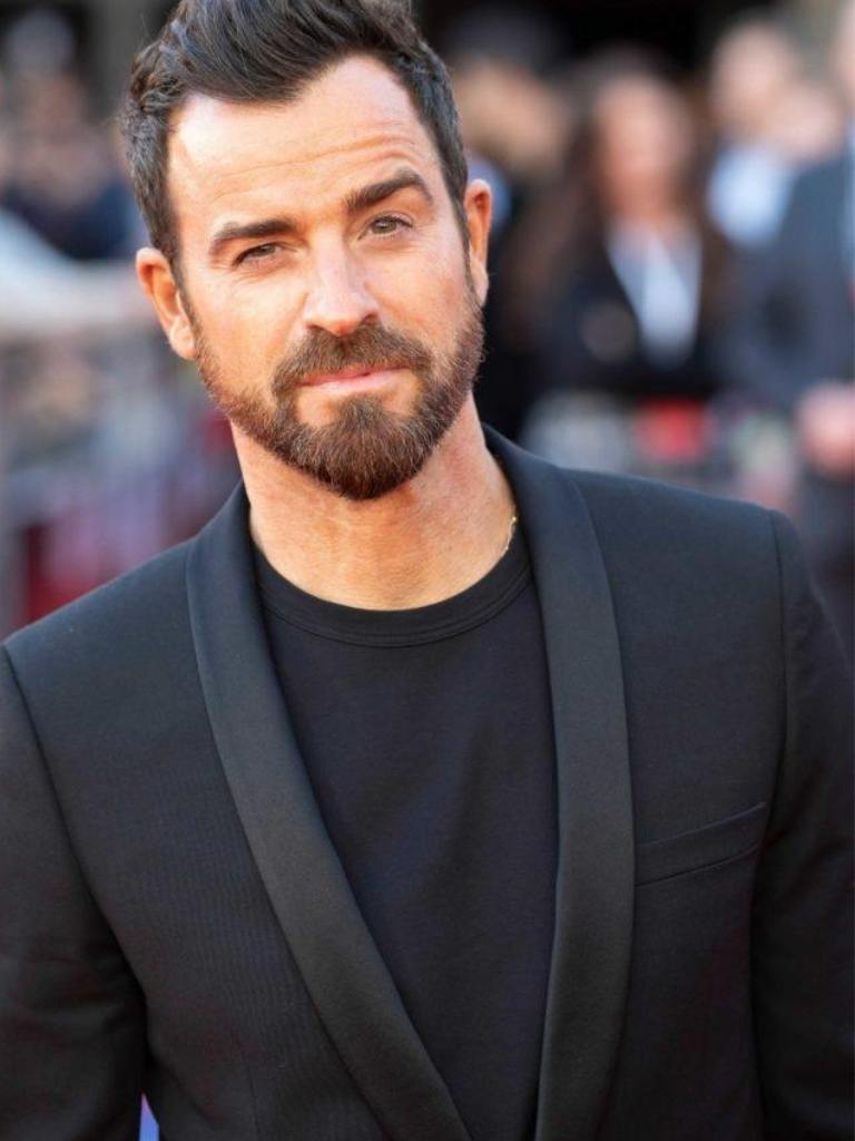 Hairstyles for receding hairline: Justin Theroux with dark brown hair styled in a quiff with a widow's peak, wearing a black t-shirt and blazer