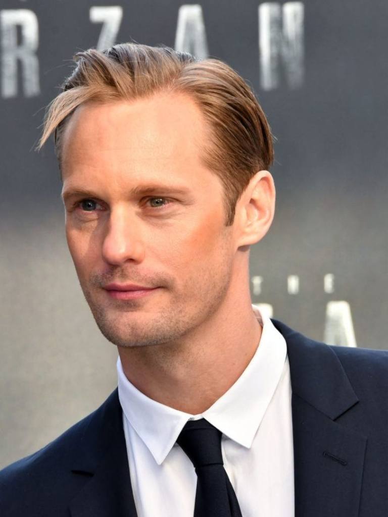 Hairstyles for receding hairline: Close-up of Alexander Skarsgard with blonde hair in a piecey side parted comb over style