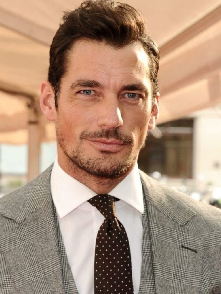 Hairstyles for receding hairline: Headshot of David Gandy with brown hair in a short brush back hairstyle