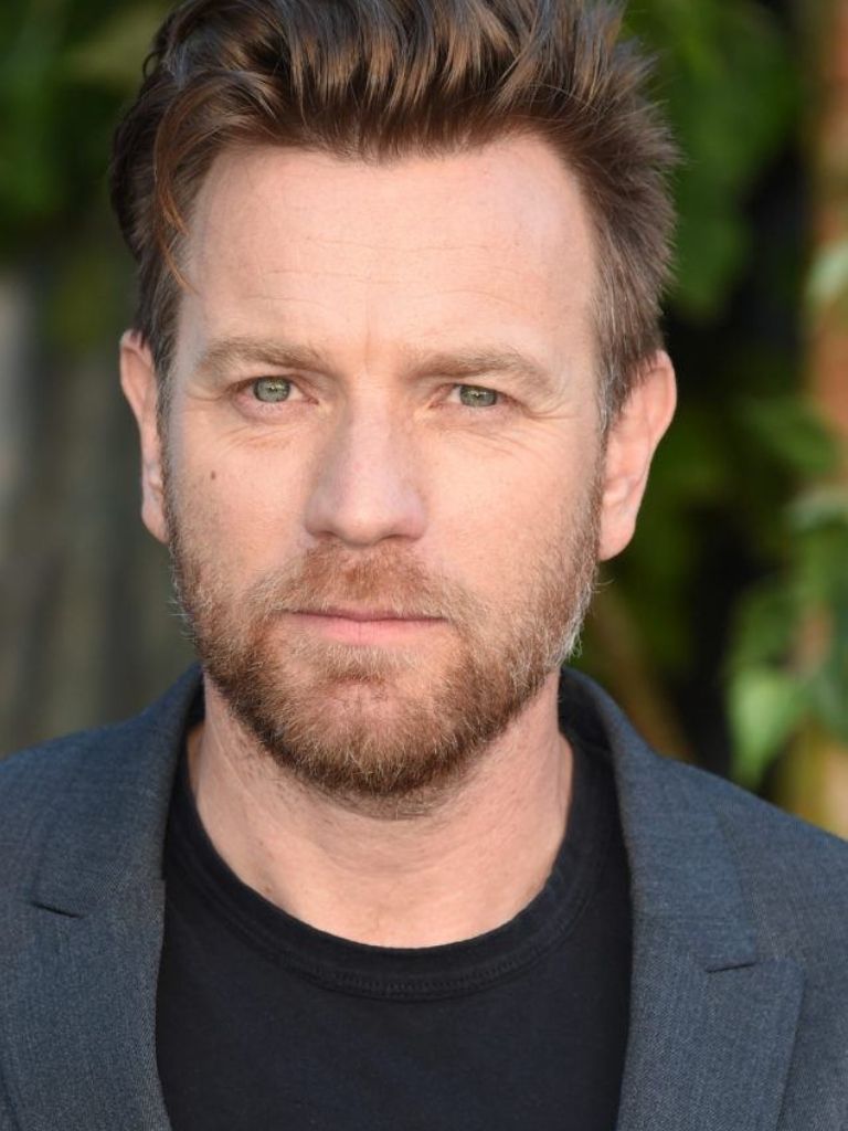 Hairstyles for receding hairline: Close-up headshot of Ewan McGregor with brown hair in a soft pomp style