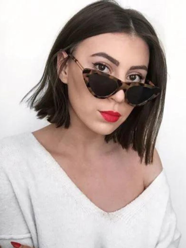 Woman with straight blunt bob short brown hair wearing dark micro cat eye sunglasses