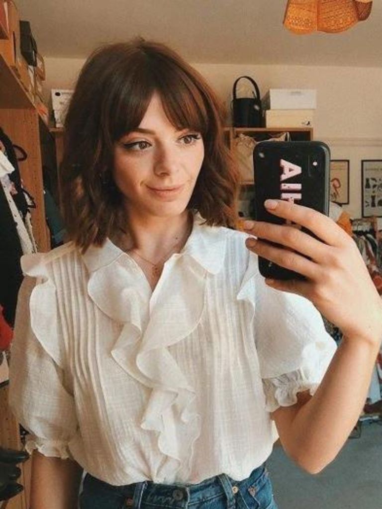 Woman with a chestnut brown bob with retro split bangs