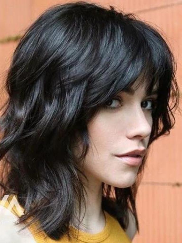 Woman with dark brown hair with a layered shag cut