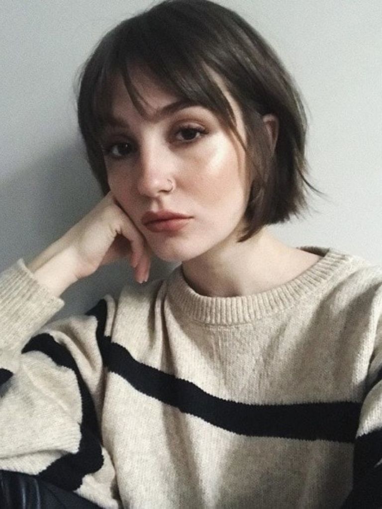 Woman with a brunette French girl inspired bob with bangs