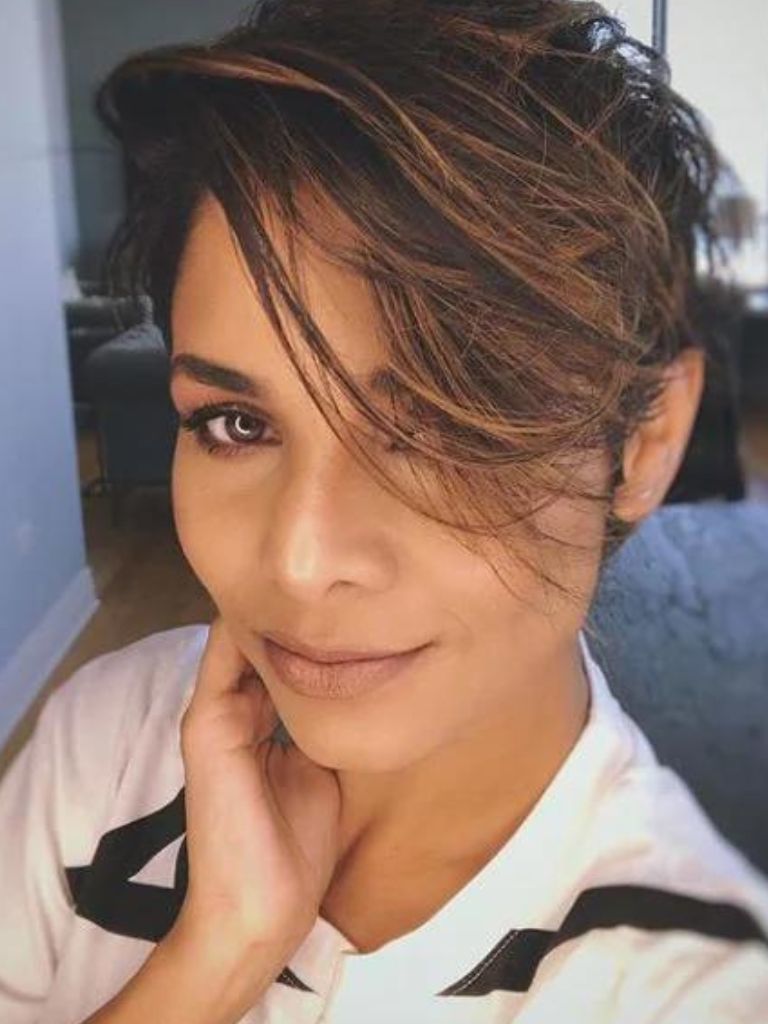 Woman with short brown highlighted hair in long pixie cut with sweeping side fringe