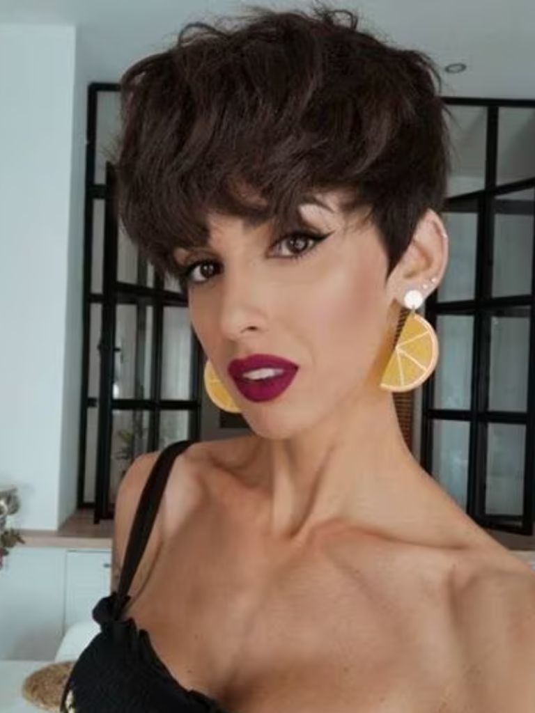 Brunette woman with a short curly pixie cut