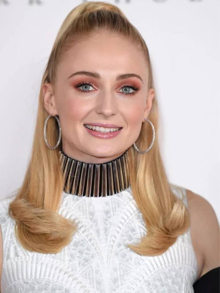 Woman with blonde hairstyle with flicked ends.