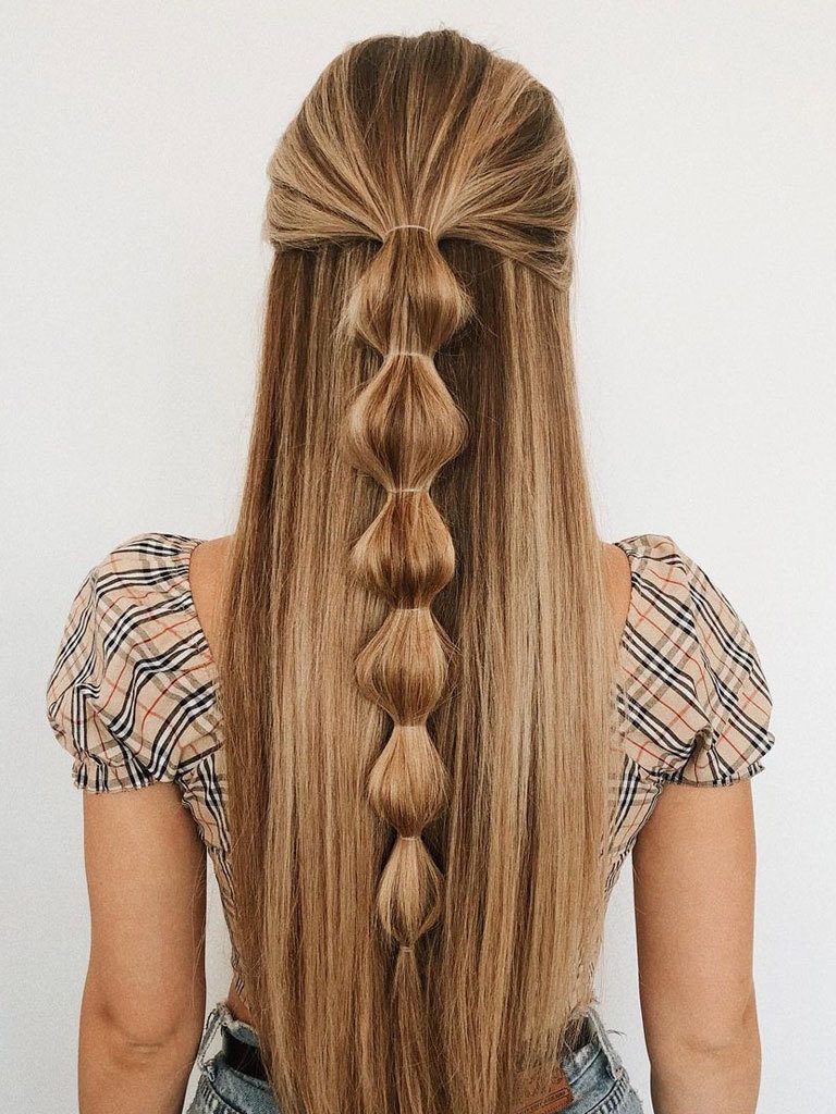 Woman with long blonde hair in half-up style with bubble braid