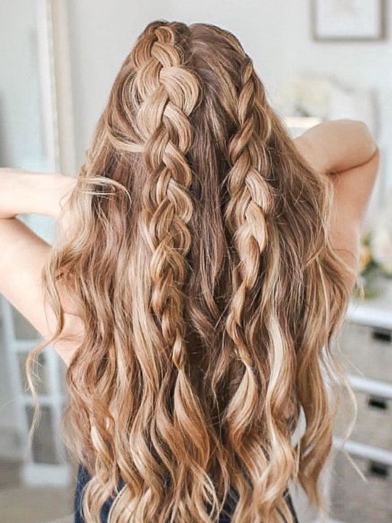 Woman with long loose wavy blonde hair with two braids