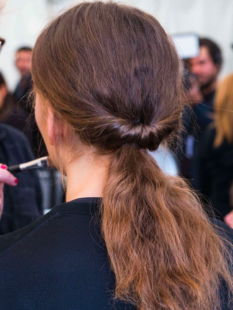 Woman with low twisted looped ponytail on long dark hair