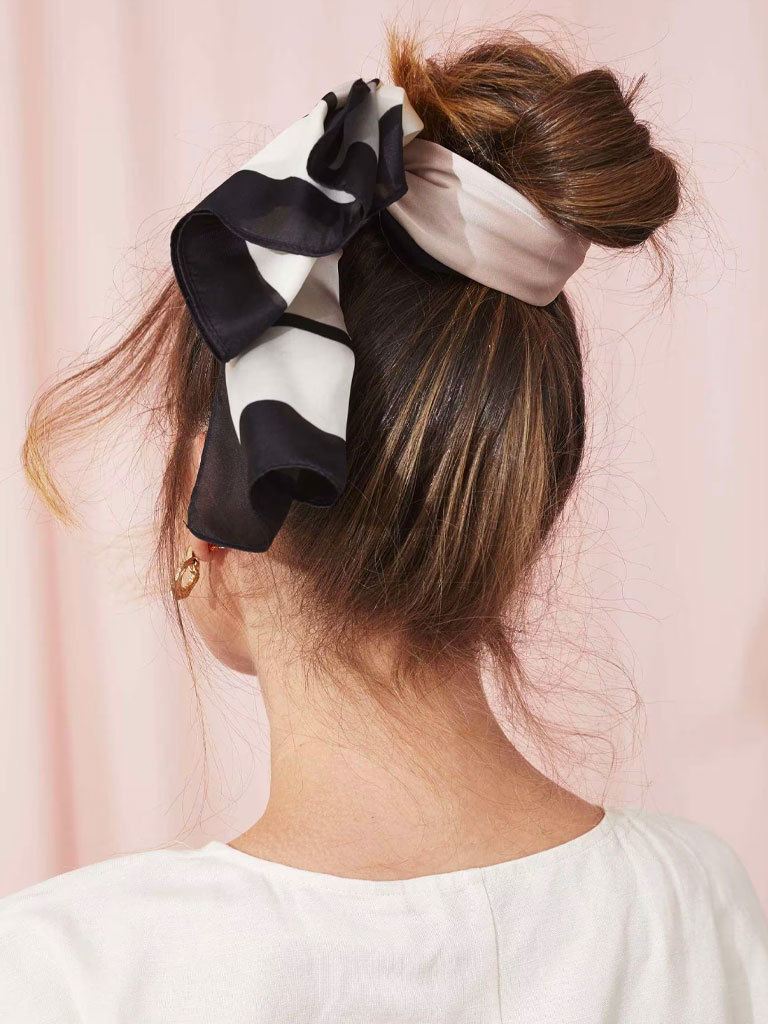 Woman with long hair styled into a messy bun