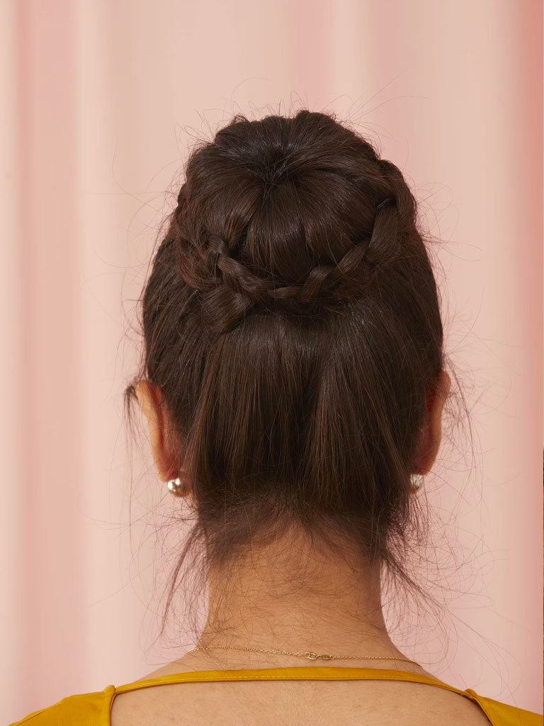 Woman with long hair styled into a braided bun
