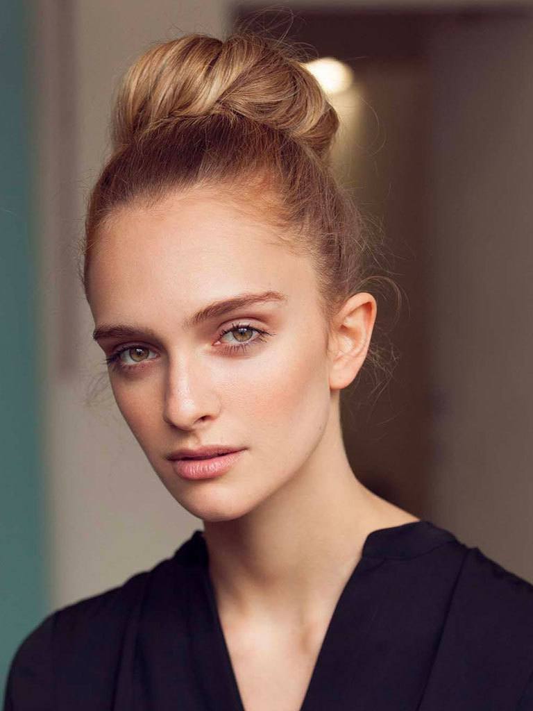 updos for long hair: Girl with long blonde hair in a high bun with donut