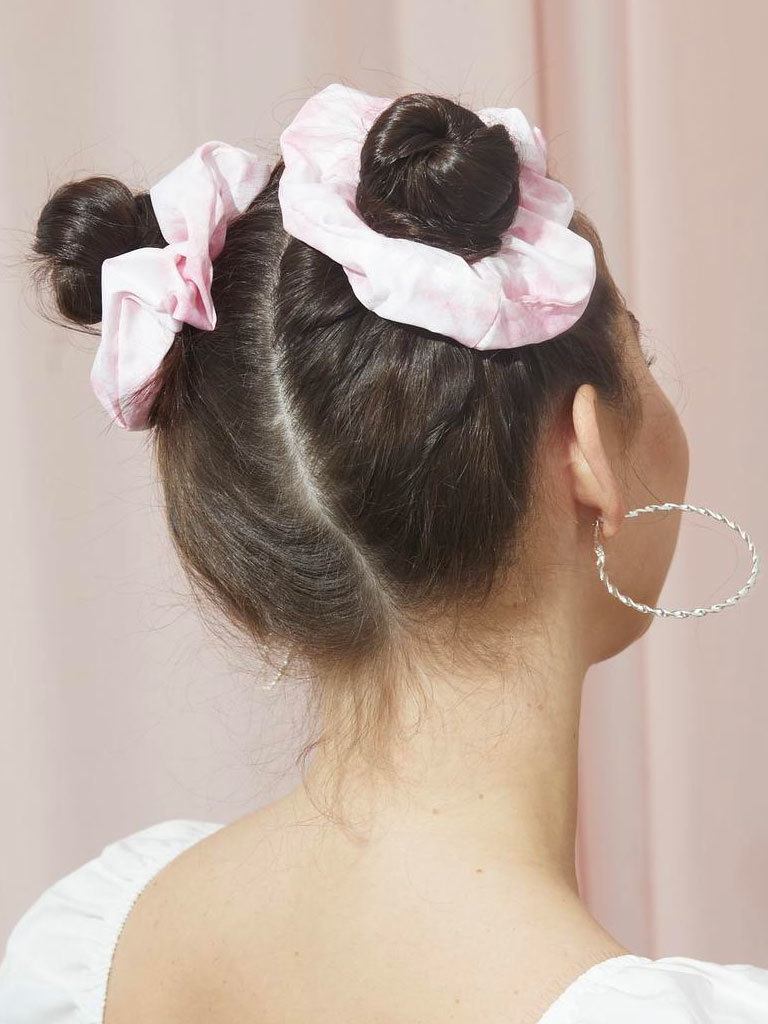 Woman with dark brown hair styled into space buns with scrunchies