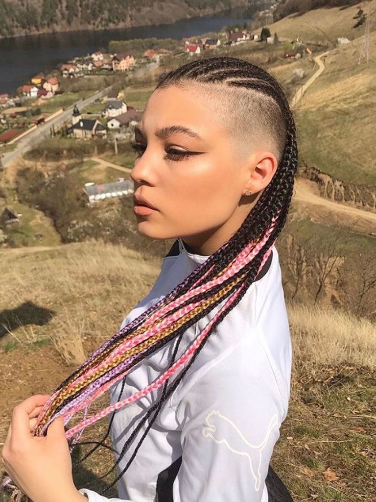 Woman with long multicoloured knotless braids with high graduated fade and shaved sides
