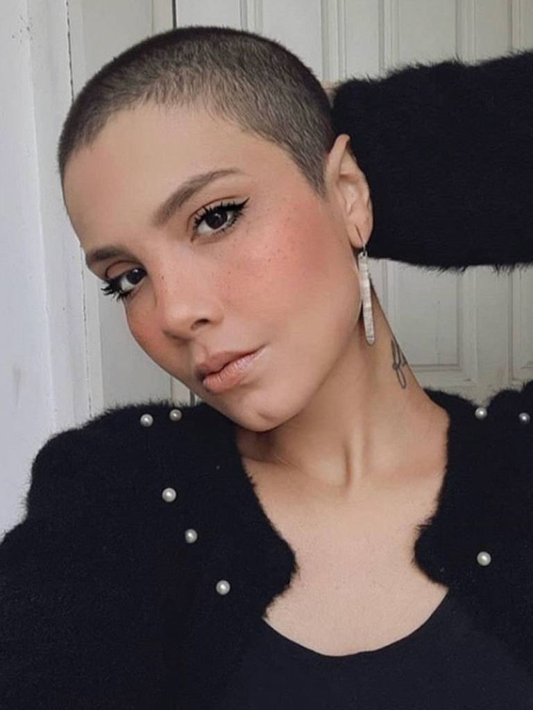 Woman with dark hair in beautiful buzzcut looking at camera