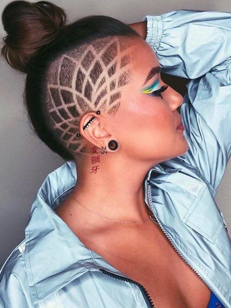 Woman with dark brown hair with a floral shaved undercut and a bun