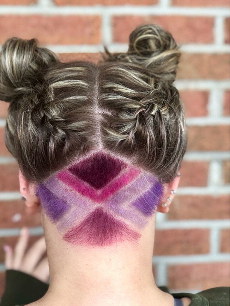 Woman with highlighted hair in braided spacebuns with a undercut coloured pink and purples