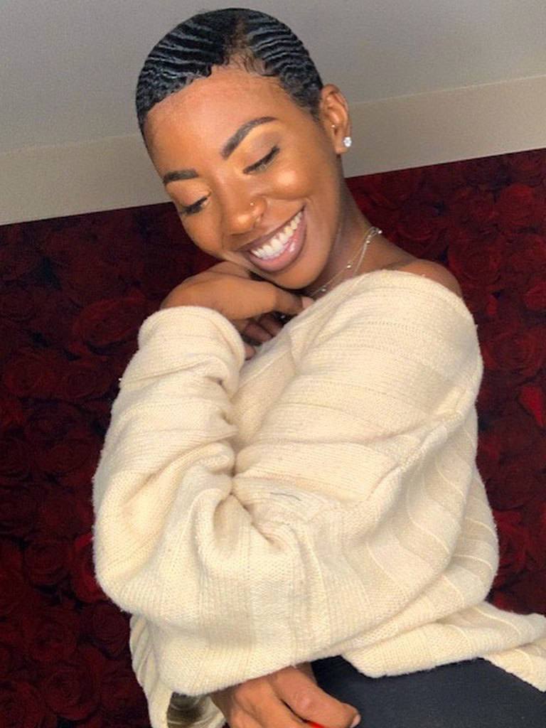 Black woman with very short hair in a retro finger wave style with shaded sideburns