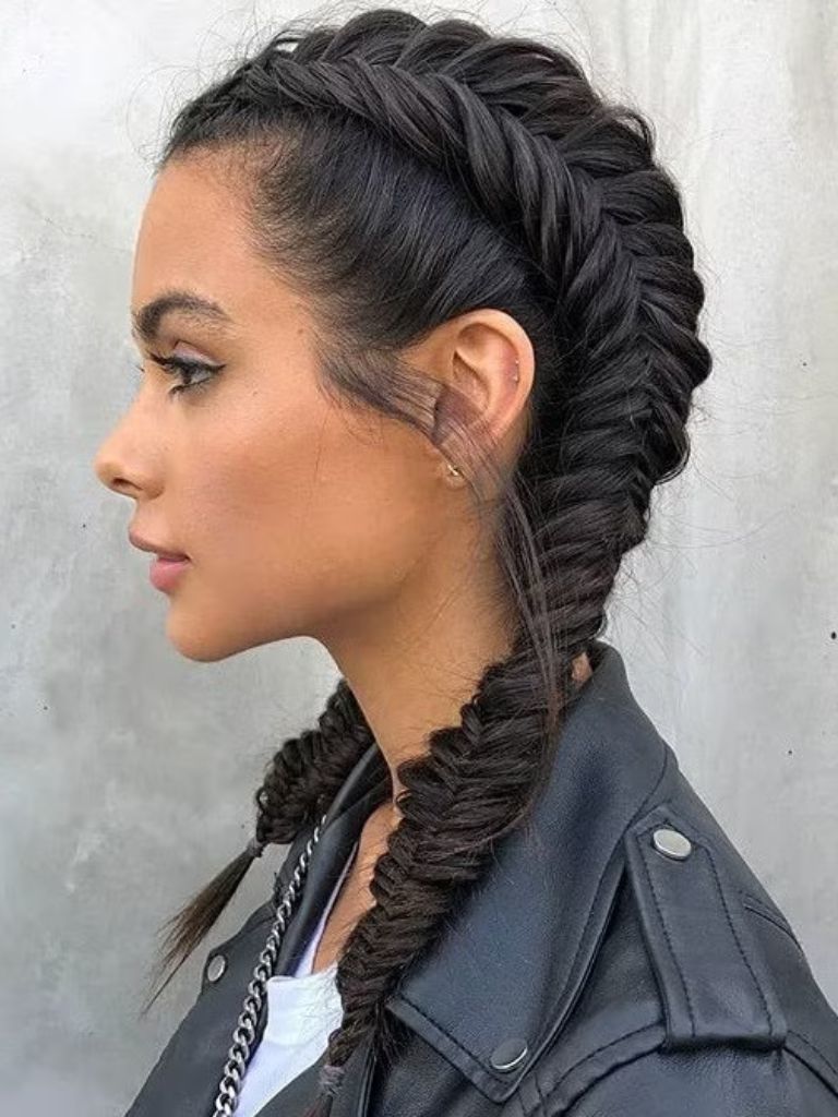 Updos with braids: Side shot of a woman with dark hair styled into a fishtail boxer braids.