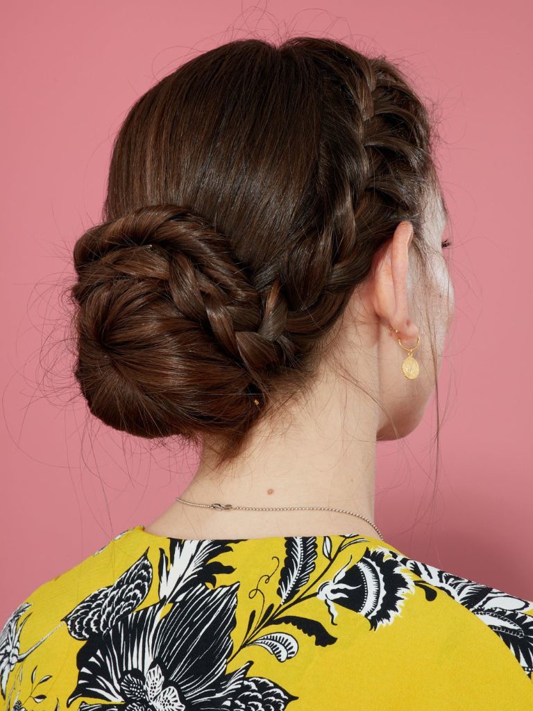 Updos with braids: Back shot of a woman with chestnut brown hair styled into a French braid updo.