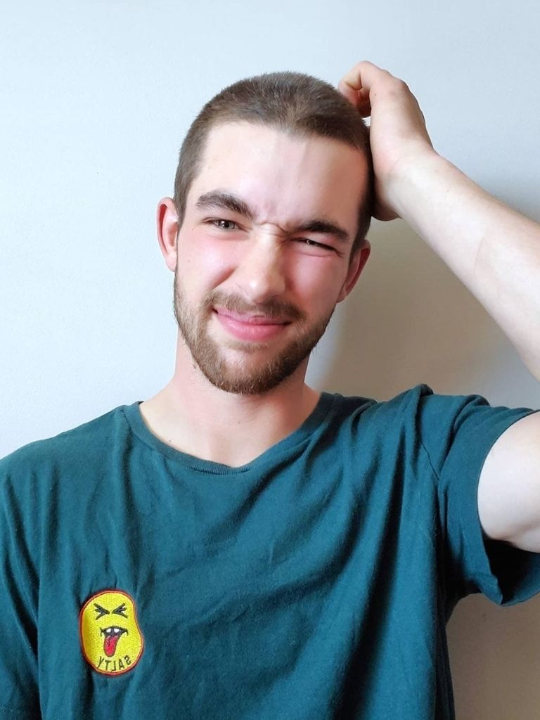 Man with brown hair with a shaved buzz cut
