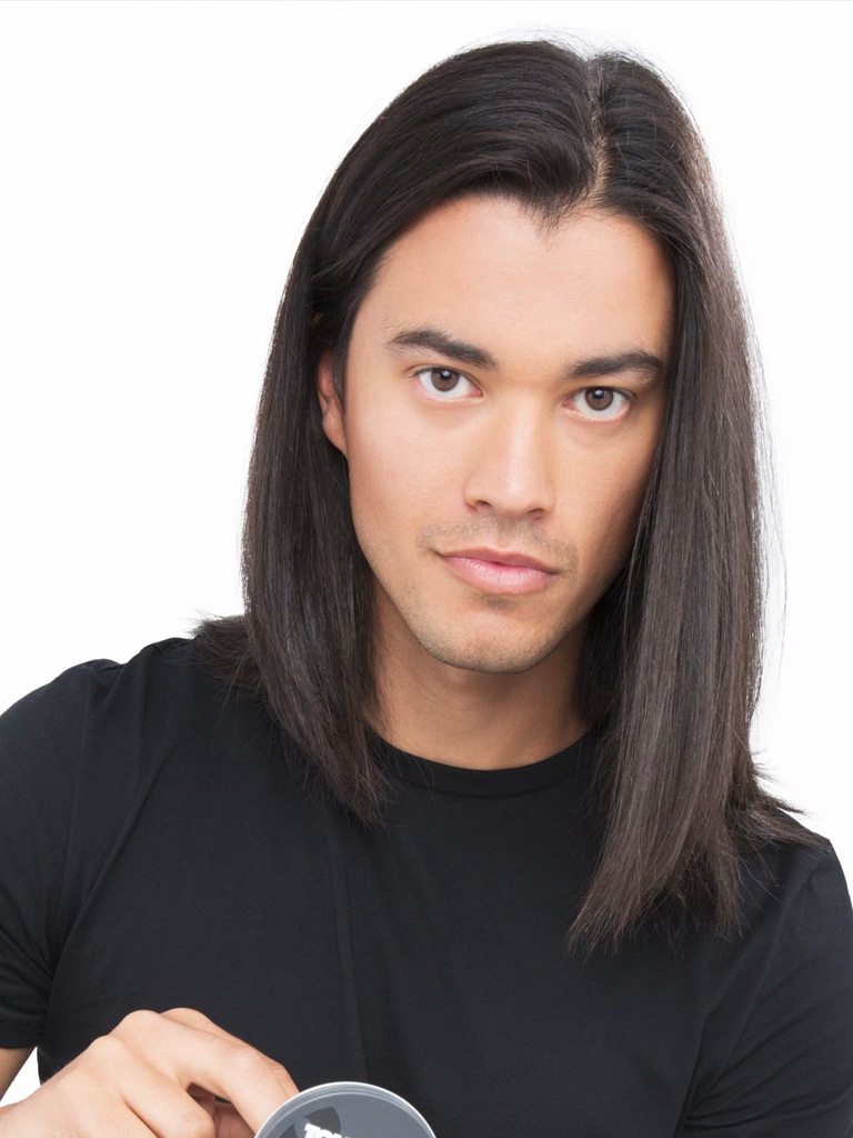 Dark haired man scooping product to his dark brown hair